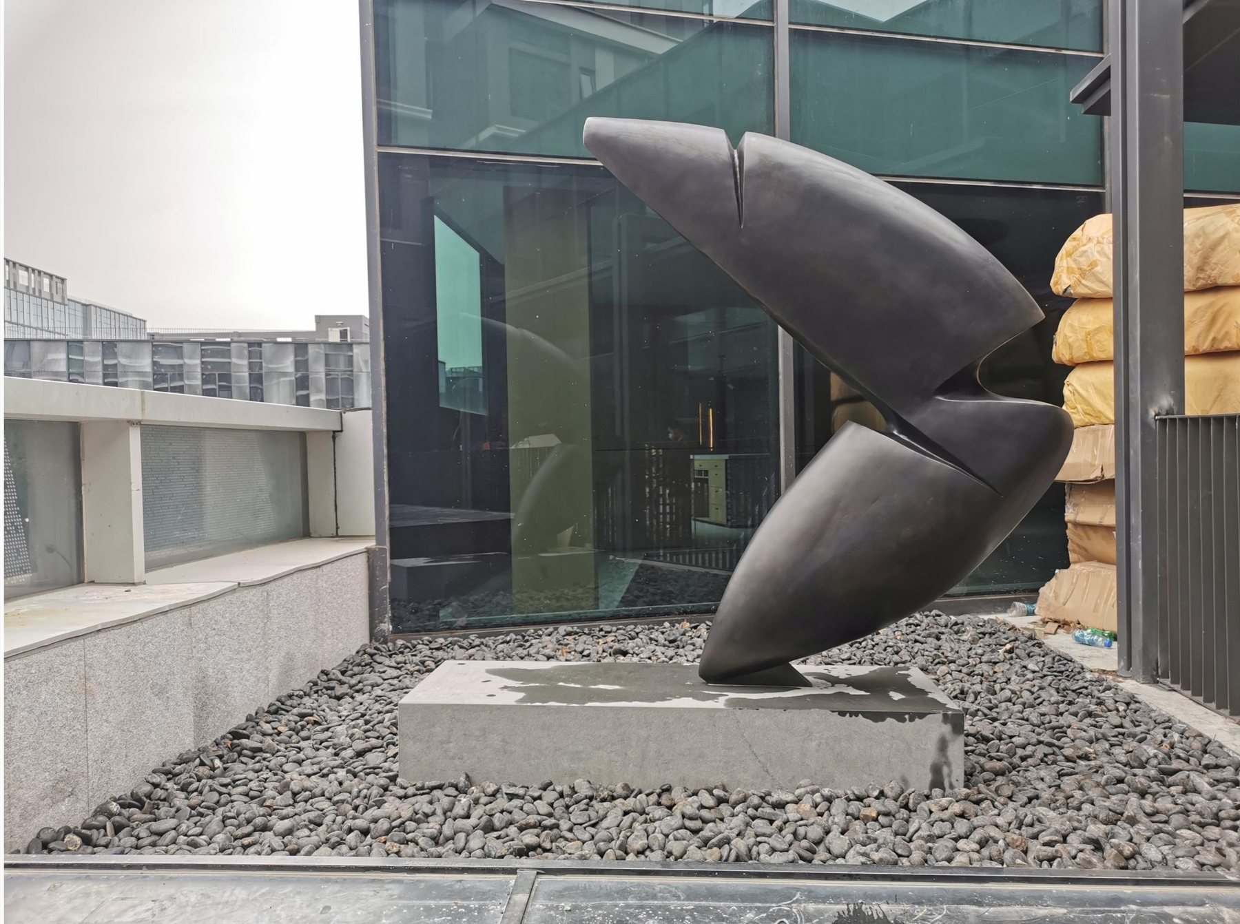 Dark abstract outdoor sculpture beside the hotel facade