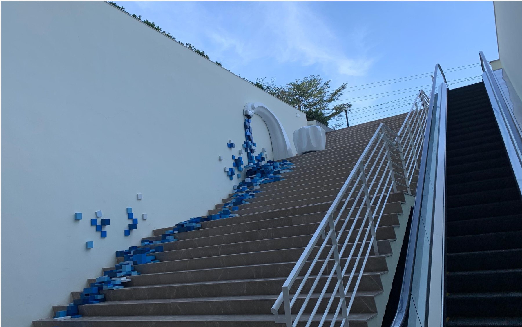 Flowing blue sculptural wall feature beside a staircase