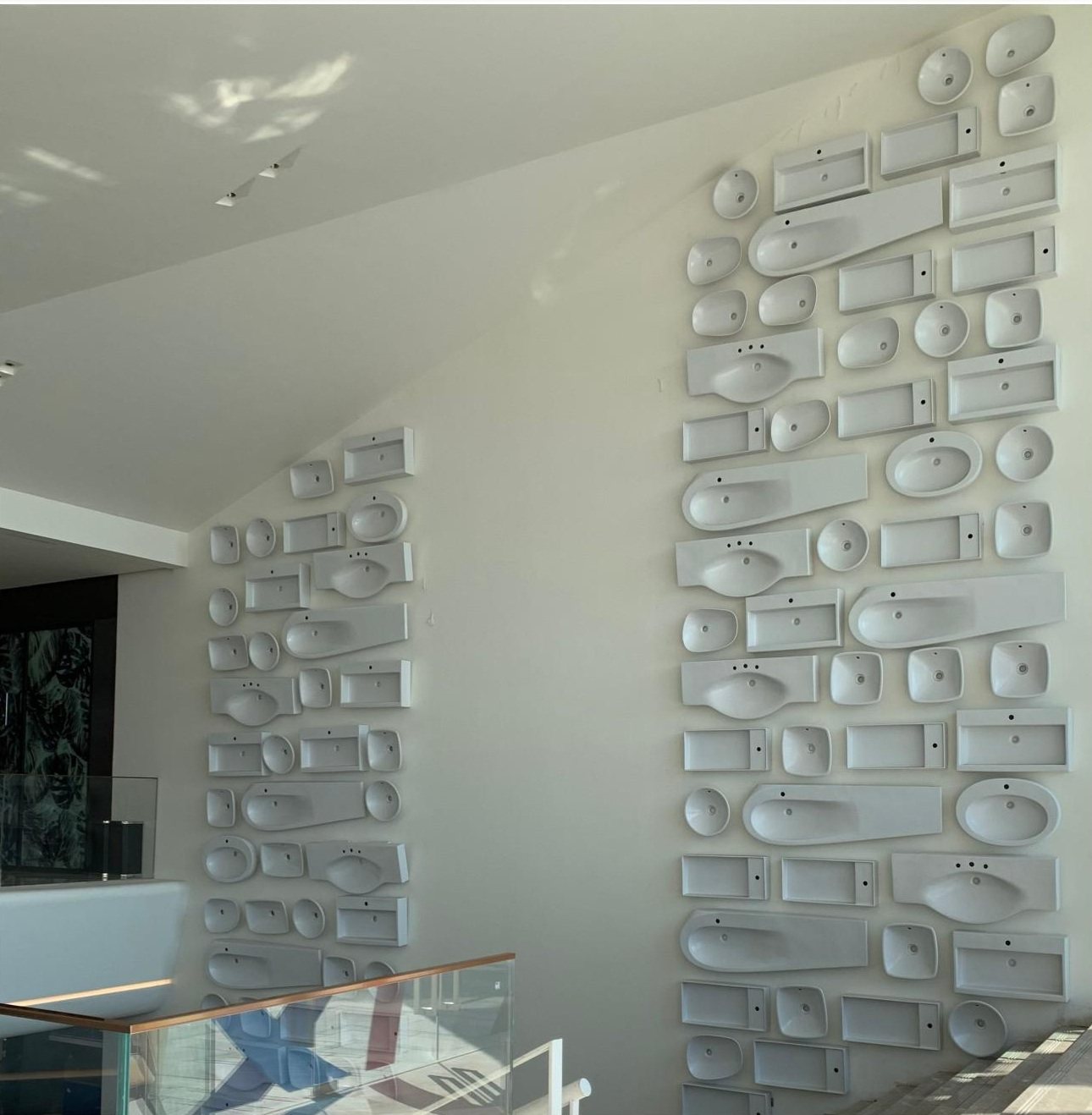 Repeated white modules forming a broad sculptural wall surface