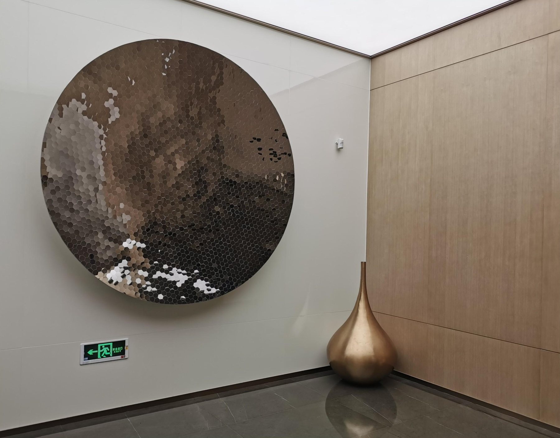 Circular wall art and gold-tone decorative sculpture in a Shenzhen Bay interior