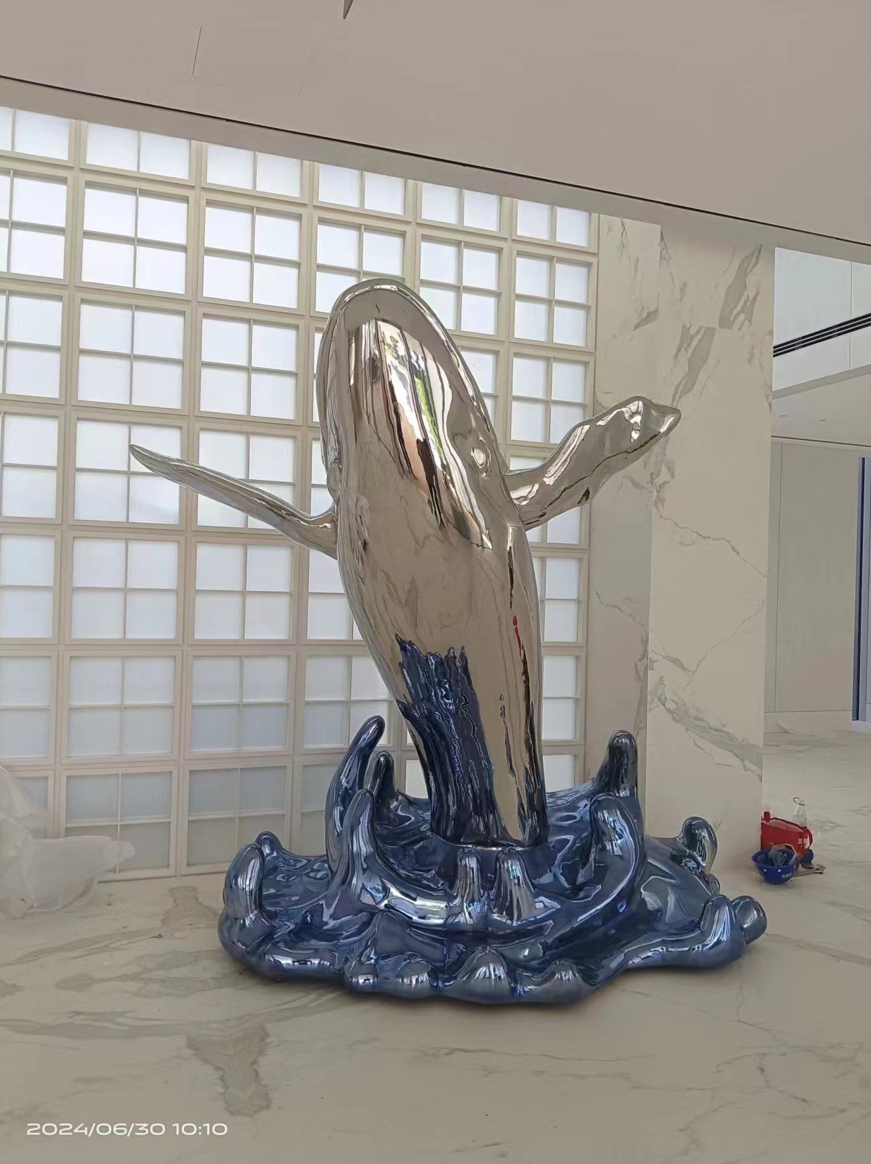 Blue and reflective vertical sculpture in a bright interior