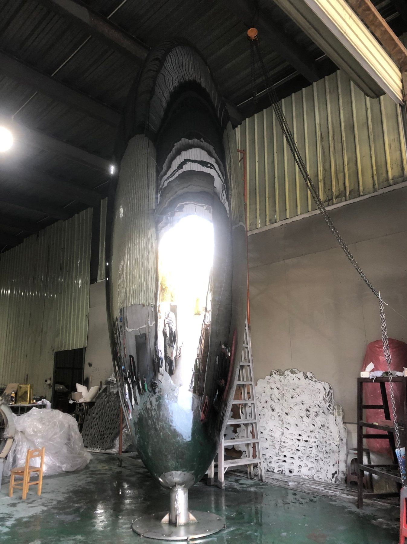 Tall polished oval sculpture during workshop preparation