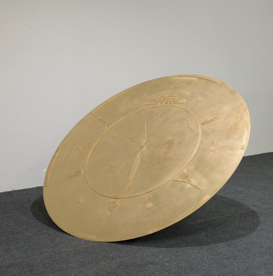 Front view of a gold-tone circular sculpture