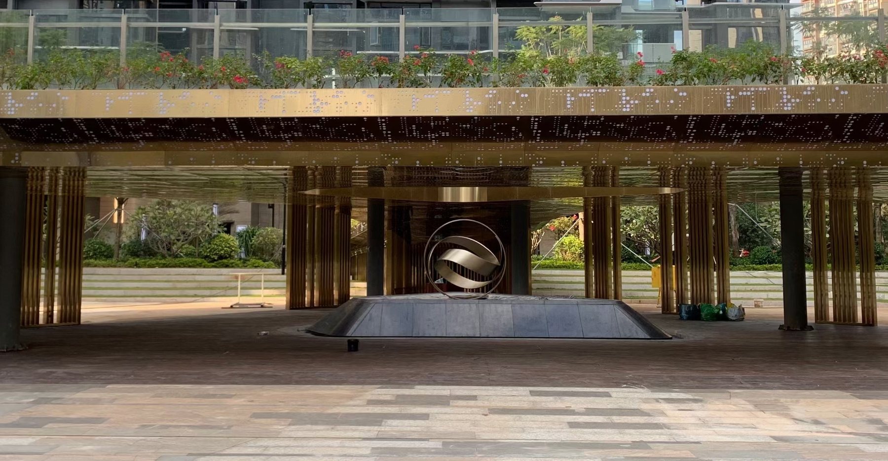 Circular sculpture positioned beneath an outdoor pavilion