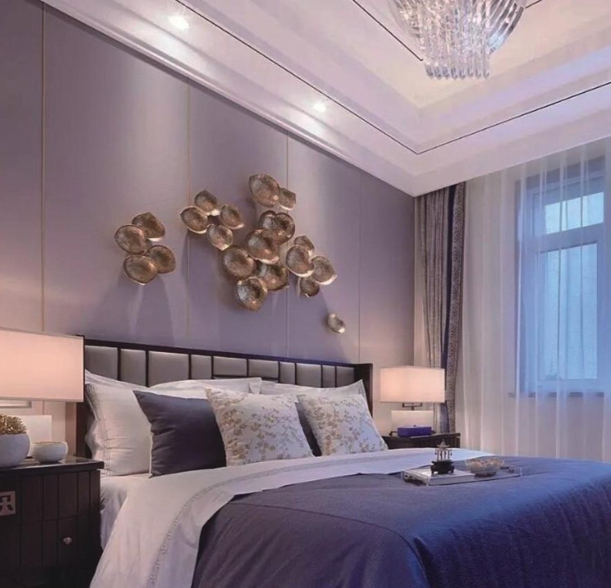 Metallic wall art above a bedroom headboard