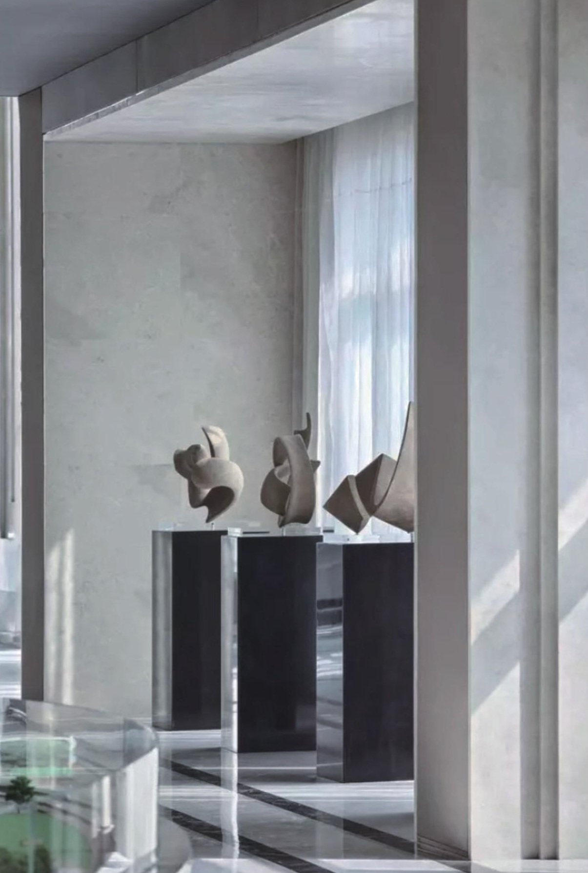 Compact abstract sculptures displayed on a dark plinth