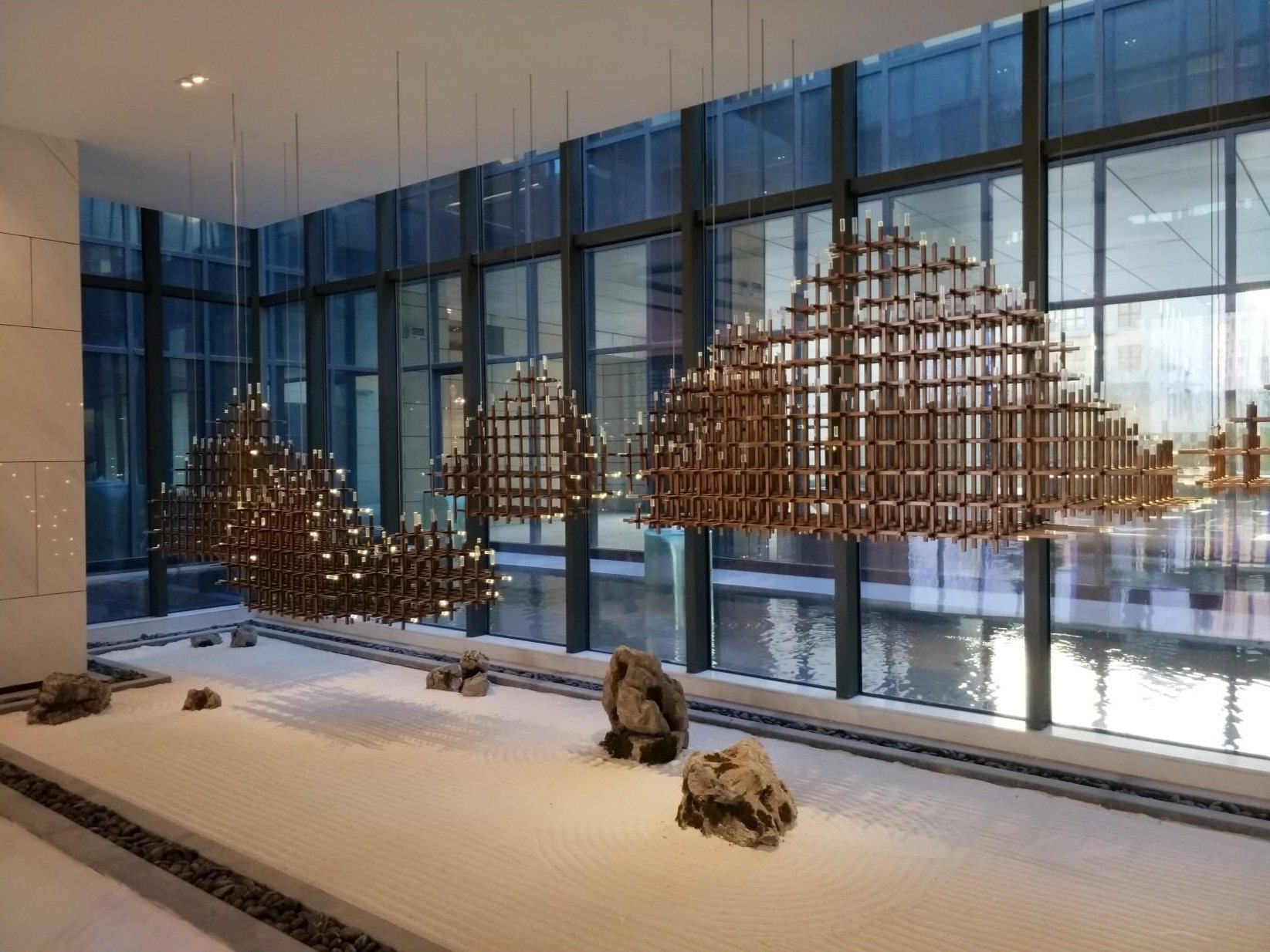 Suspended mountain-like artwork above a hospitality space