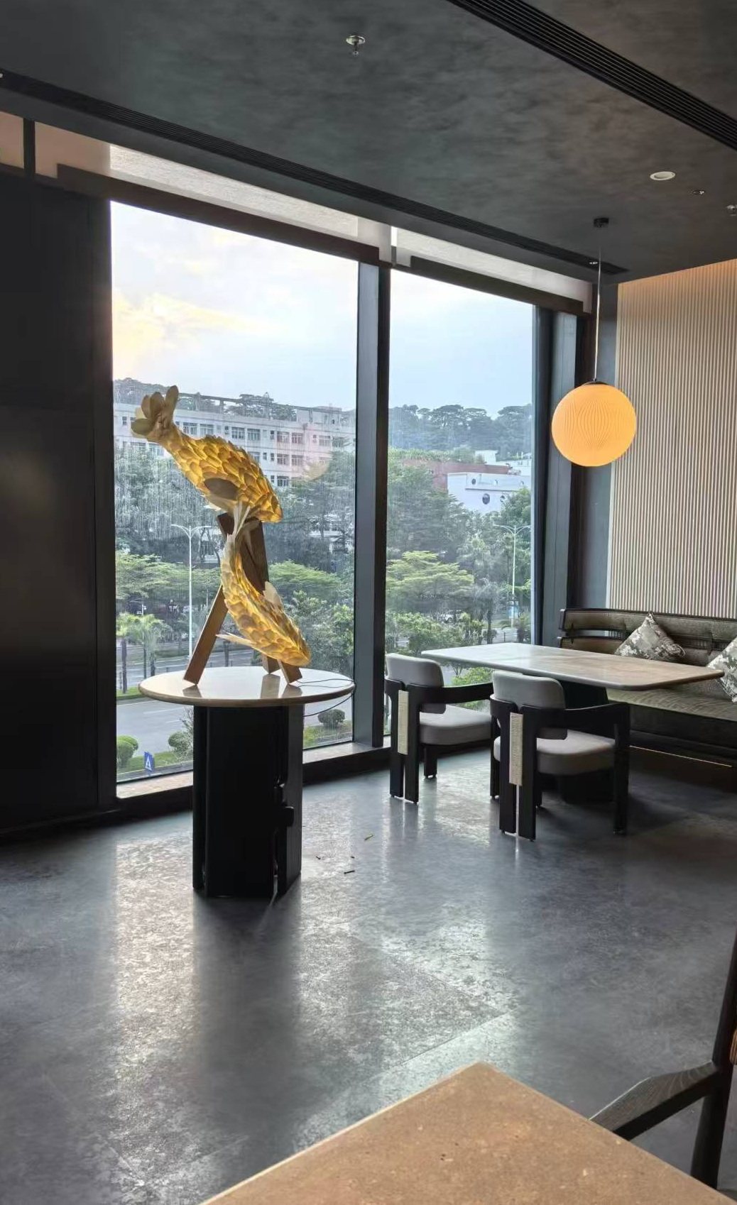 Gold-tone figurative sculpture beside a hotel window