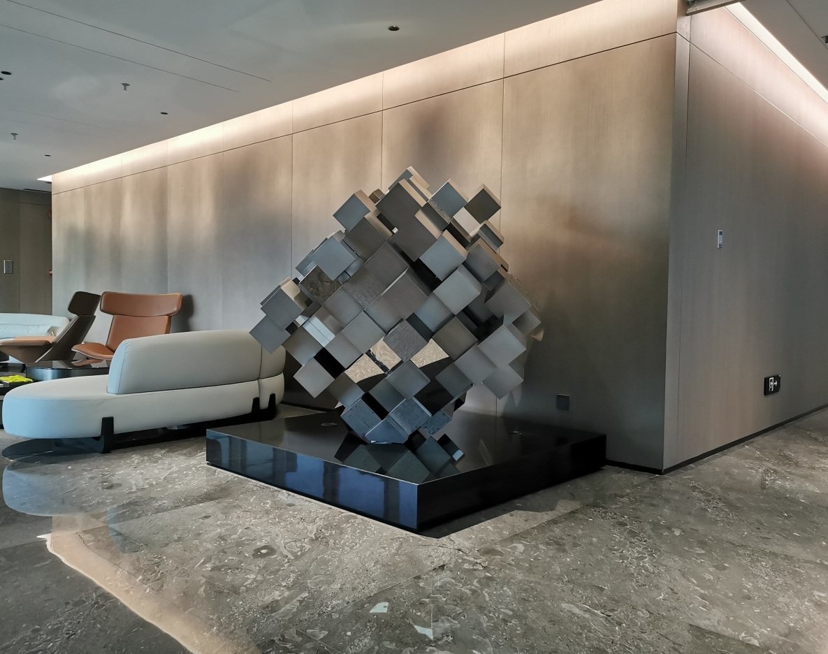 Mirrored geometric sculpture on a dark base in a hotel lounge