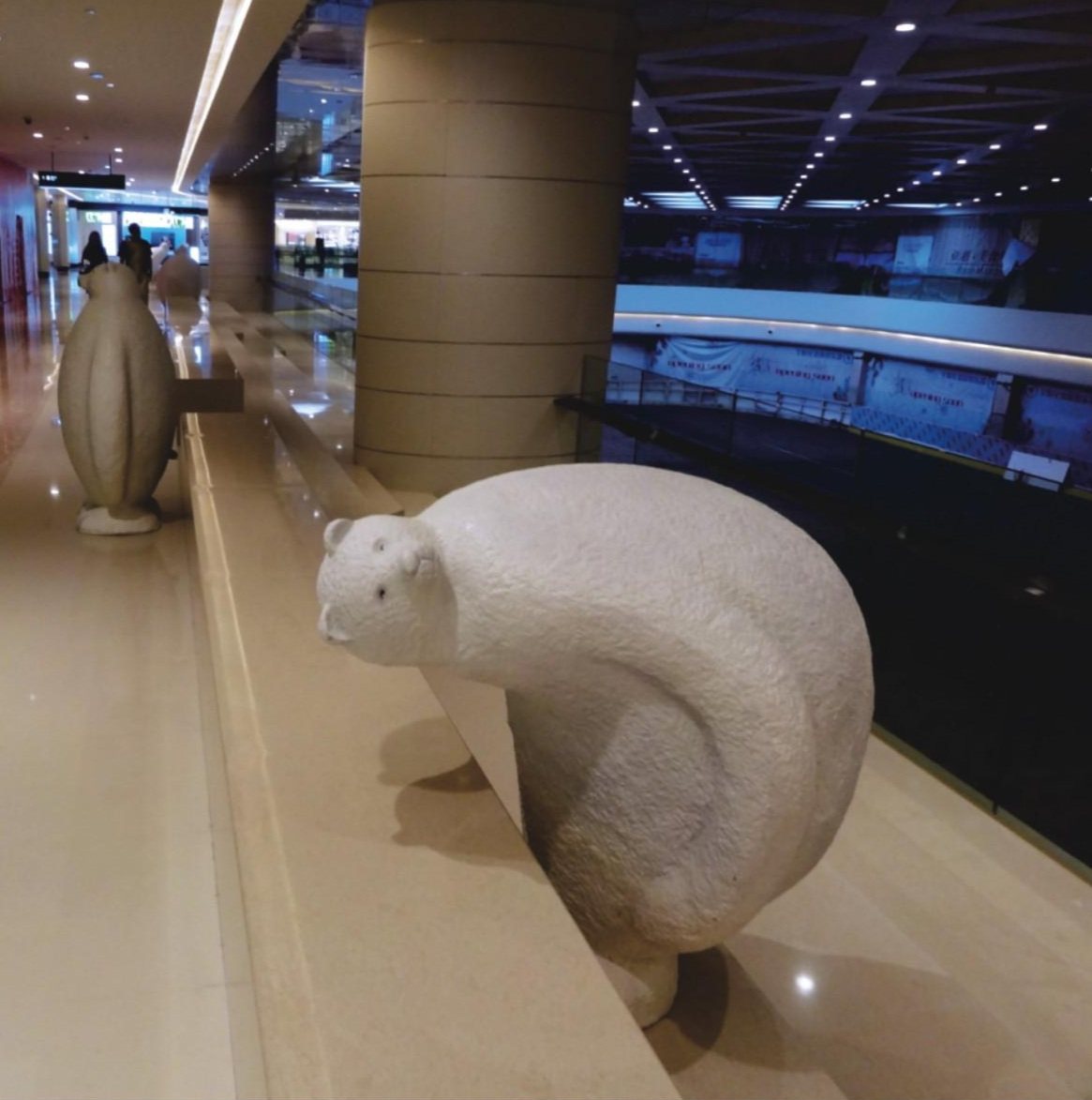 White textured animal sculpture along an upper-level walkway