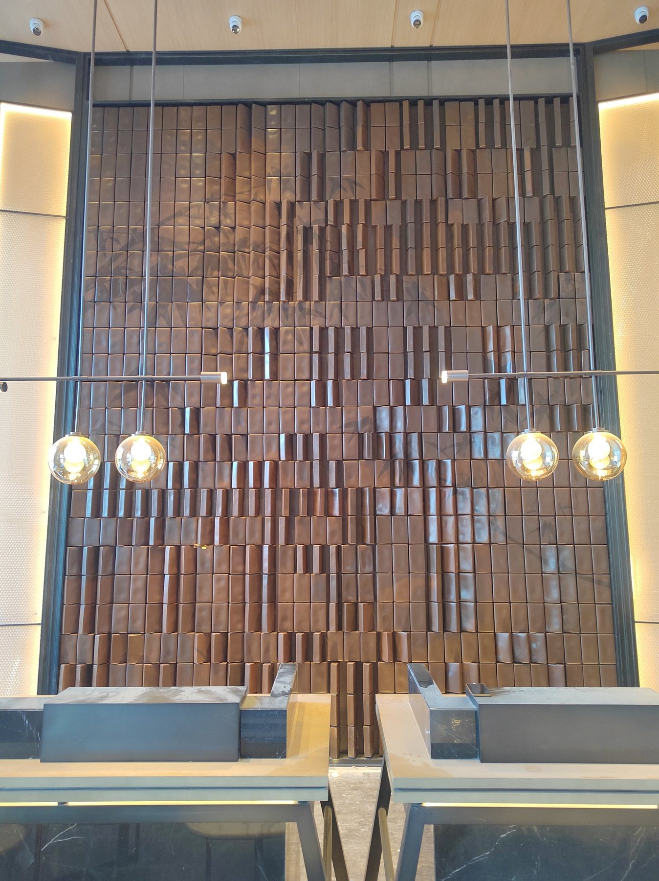 Completed bronze-tone modular feature wall in the Yuyao Hilton interior