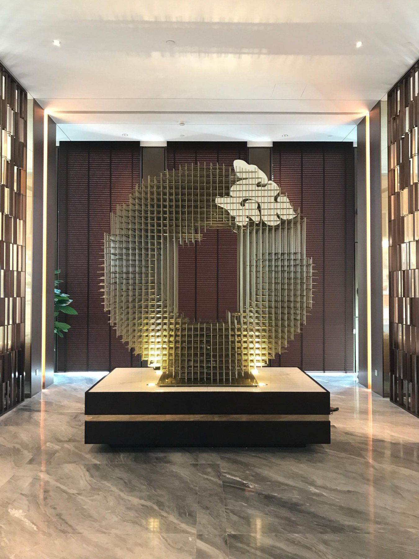 Circular gold-tone suspended artwork in the Hengqin headquarters lobby