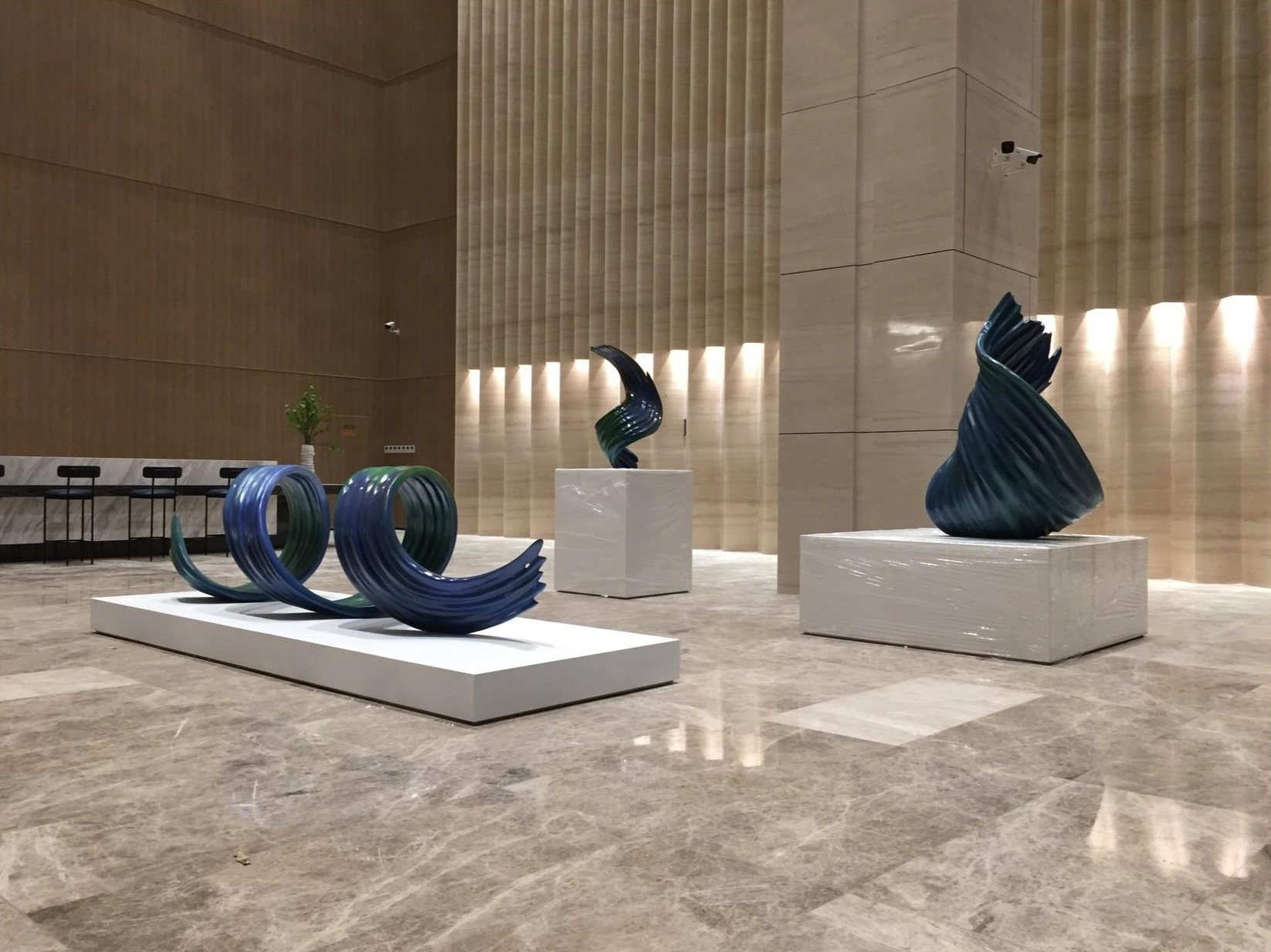 Coordinated blue and green sculptures displayed in a commercial lobby