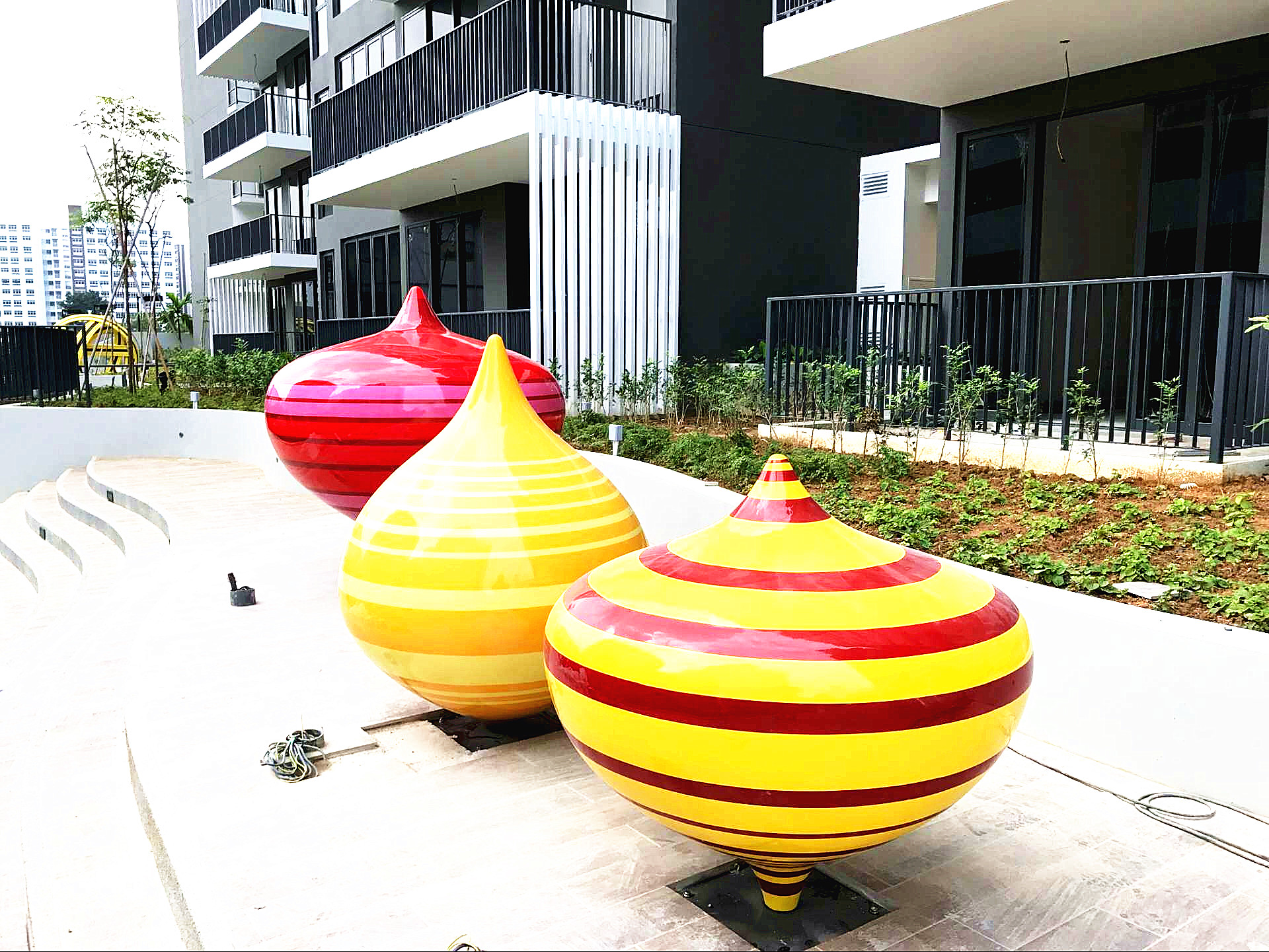 Custom fiberglass yo-yo ball sculptures installed in an outdoor residential landscape