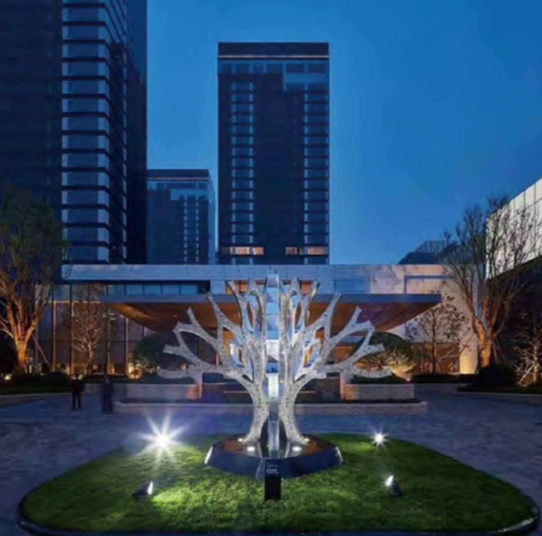 Tree-like illuminated sculpture installed in a residential landscape